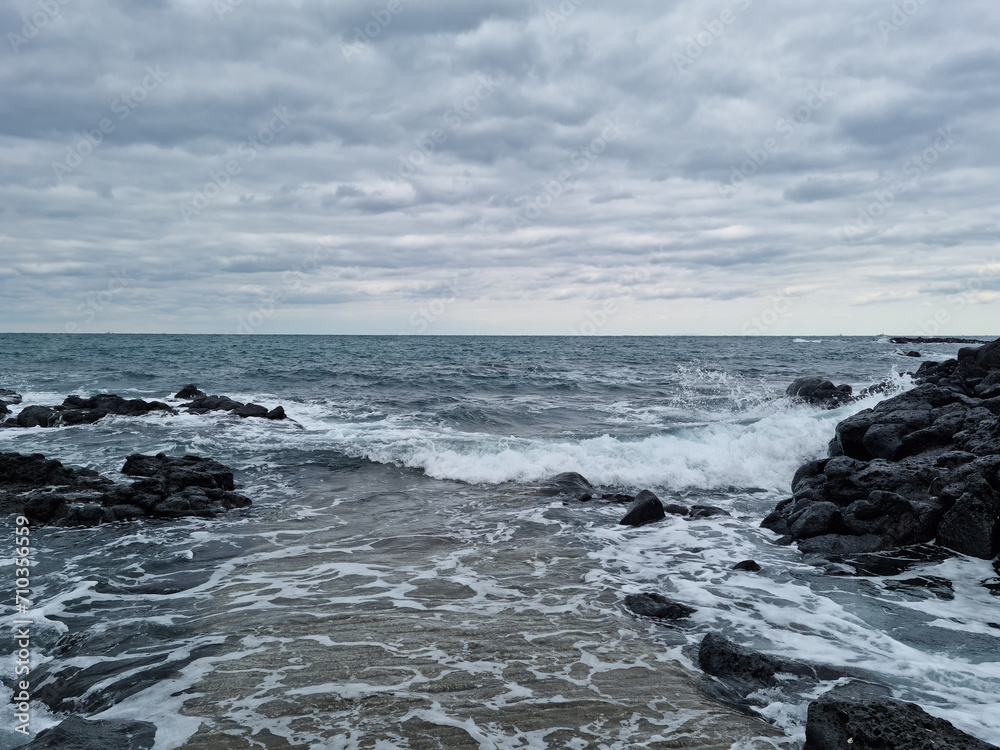 The rough sea of ​​Jeju is covered in dark clouds.