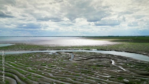 Cracked mud flats in a salt marsh. Aerial: Tidal mudflats, Abstract textures in a cracked coastline, Salt marshes at low tide exposing mud flats and streams at Freiston Shore Lincolnshire UK photo