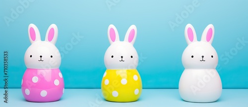 Three polka-dotted Easter bunny figurines against a blue background