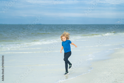 Summer vacation concept. Happy little kid running on the beach, walking on sea sandy beach. Travel adventure kids concept. Lovely kid run outdoor. Pretty little child relaxing on the beach near sea.