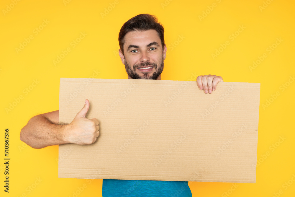Good choice, recommend like concept with copy space. Man with thumb up and blank banner ad, on studio background. Portrait of man holding empty blank poster. Good choice, recommend like concept with copy space. Man with thumb up and blank banner ad, on studio background. Portrait of man holding empty blank poster.