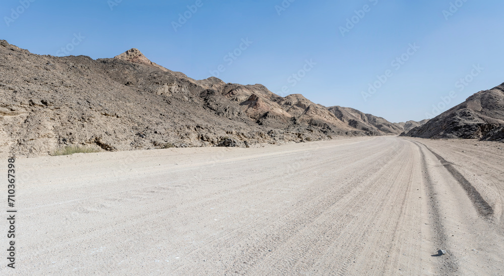 gravel road and barren slopes in hilly landscape at Moonlandscape, near Swakopmund, Namibia gravel road and barren slopes in hilly landscape at Moonlandscape, near Swakopmund, Namibia