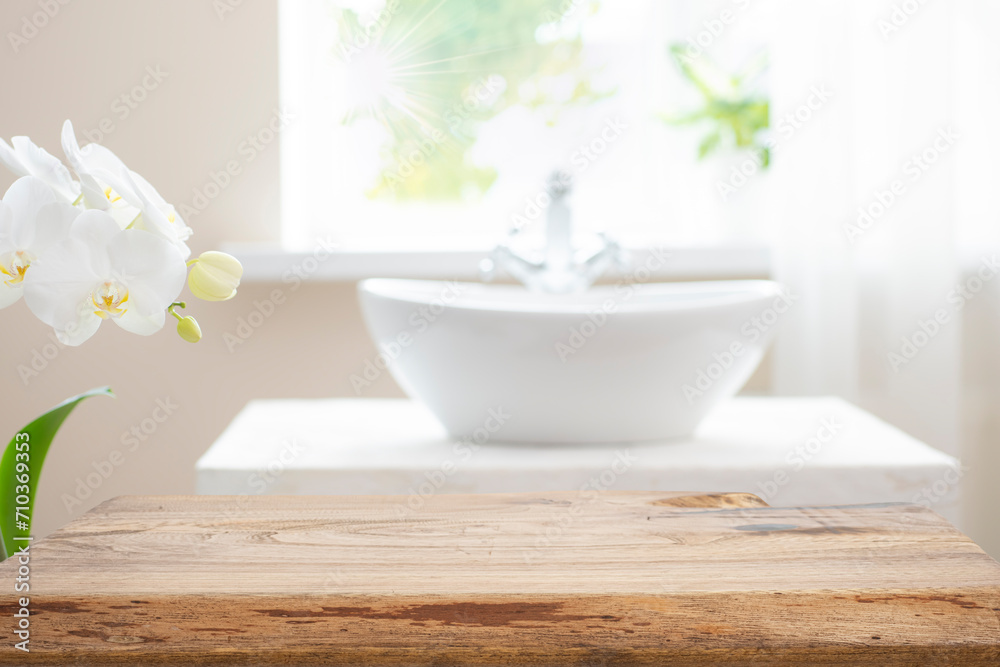 Fototapeta premium Wooden table top with copy space on blurred bathroom sink and window background
