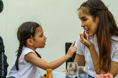 Obraz na płótnie A half-breed child is pointing at something stuck in her mother's tooth
