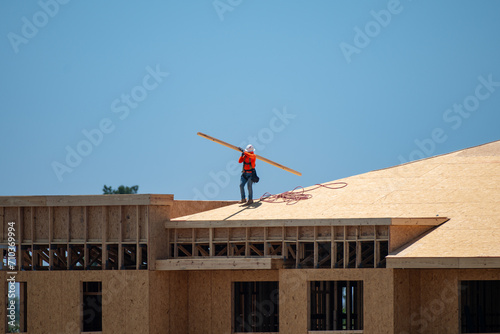 Wooden roof. Roofs repair. Roofer worker install new roof on top roof. Big roof beams. An construct wooden roofs beam from framework of trusses frames for newly constructed stick house.