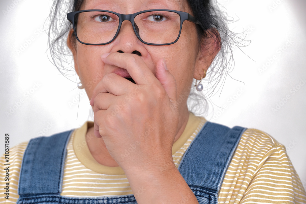 Facial expression of an Asian woman looking shocked with hand covering her mouth