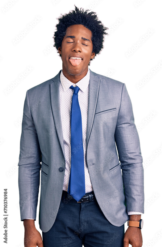 Handsome african american man with afro hair wearing business jacket sticking tongue out happy with funny expression. emotion concept.
