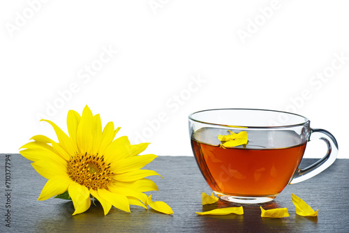 Black tea in the glass cup and sunflower near isolated on a black surface .Isolated on a white background. Copy space.