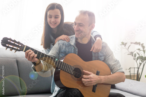Artistic talented girl showing her latin music teacher the new song she learned to play on the acoustic guitar at home