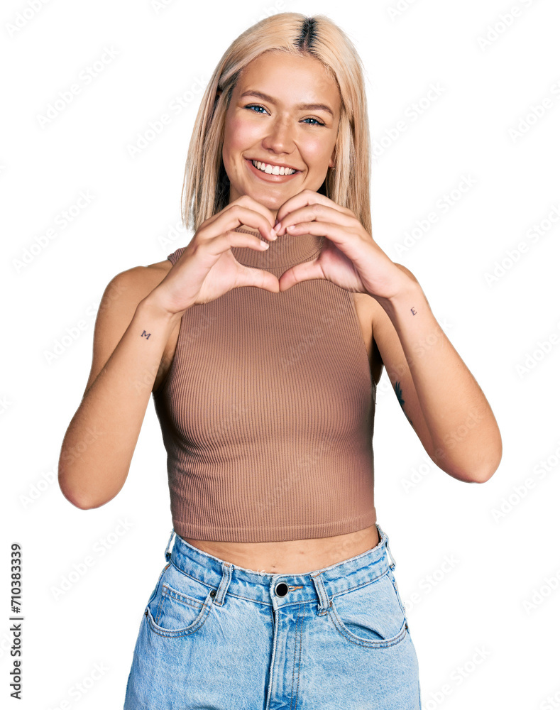 Beautiful young blonde woman wearing casual style with sleeveless shirt smiling in love doing heart symbol shape with hands. romantic concept. Beautiful young blonde woman wearing casual style with sleeveless shirt smiling in love doing heart symbol shape with hands. romantic concept.