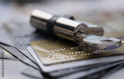 Lock with key rests on plastic credit cards. Banking security and fraud concept