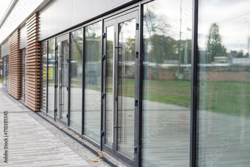 The front door of a office block  reflecting buildings in the glass