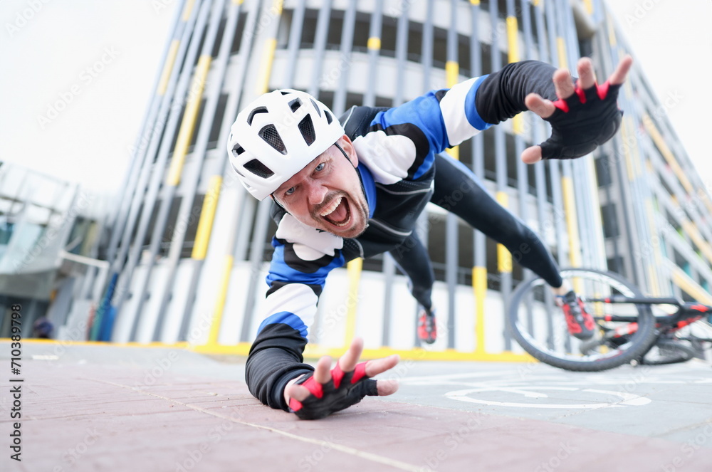 Obraz premium Young male cyclist wearing helmet and protective gear fell off bike and flying portrait. Accident insurance concept