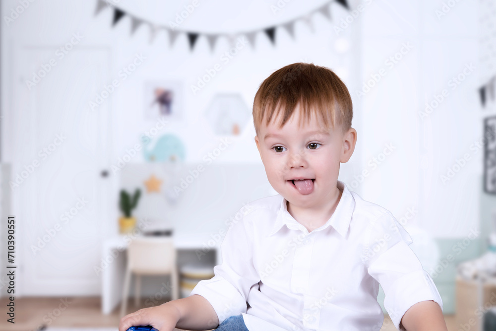 A handsome boy with joyful emotions on his face plays in the children's room. Educational games with children. Child psychology. A handsome boy with joyful emotions on his face plays in the children's room. Educational games with children. Child psychology.