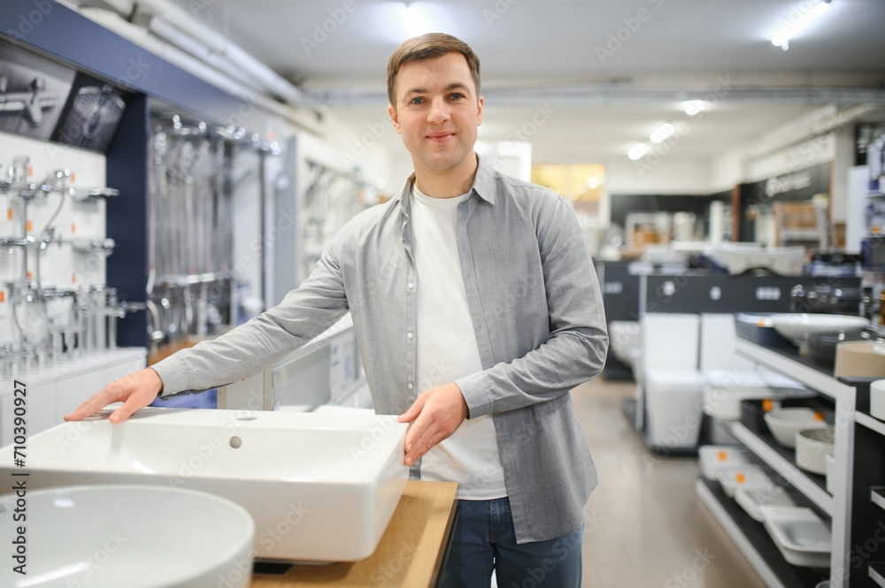 Middle age man choosing bathroom sink and utensils for his home Middle age man choosing bathroom sink and utensils for his home