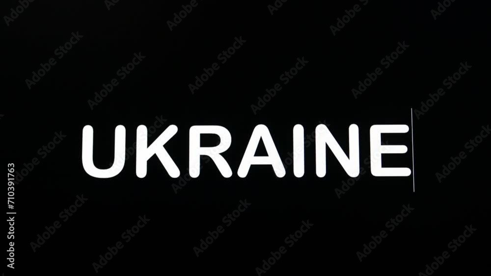 Typing the letters of Ukraine in uppercase and boldface as shown on a black background of the computer screen.