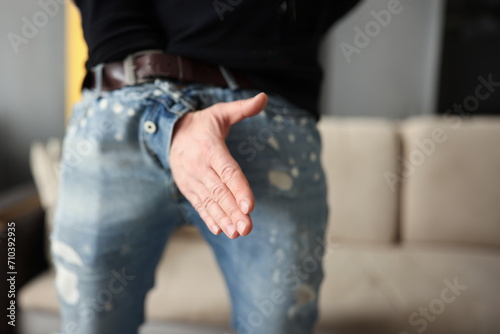 Man offers a handshake through fly of his pants. Business fraud concept