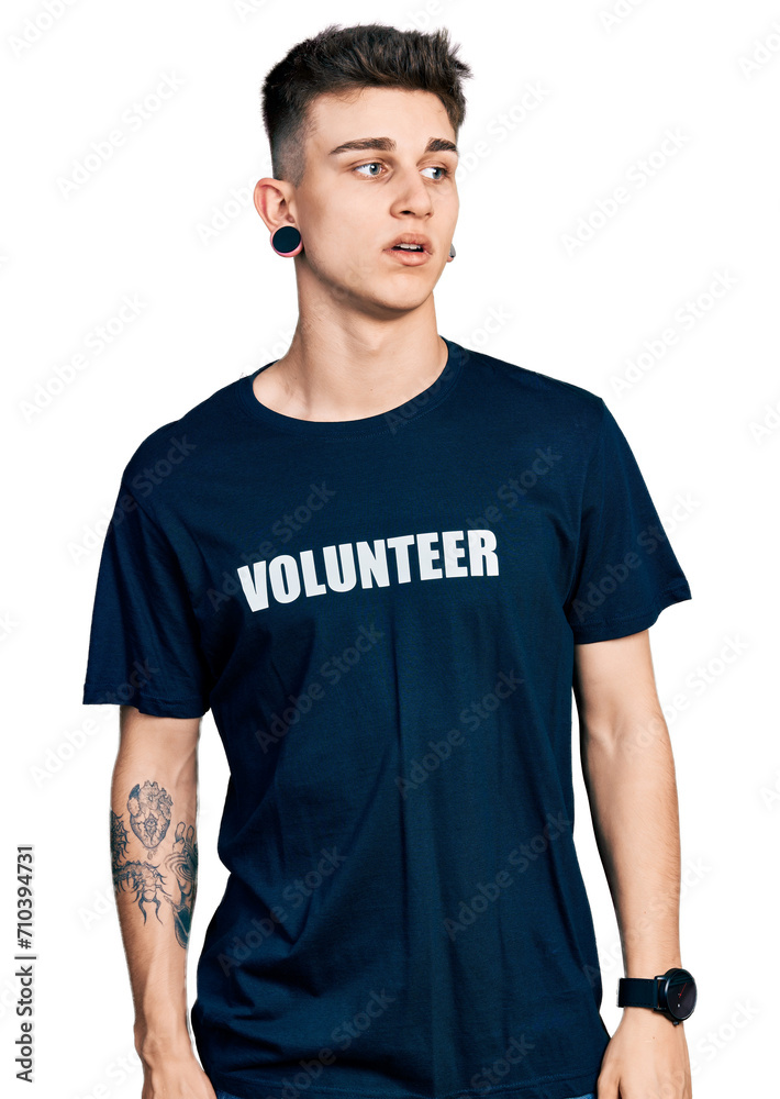 Young caucasian boy with ears dilation wearing volunteer t shirt looking sleepy and tired, exhausted for fatigue and hangover, lazy eyes in the morning.