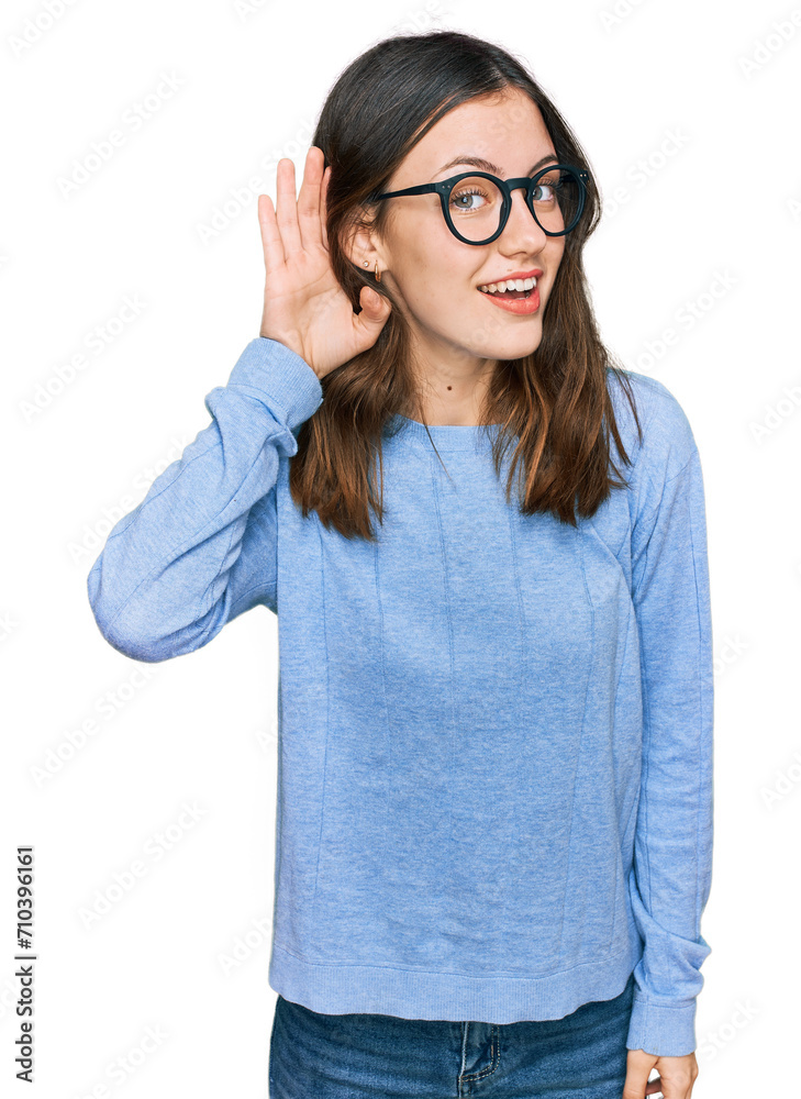 Young beautiful woman wearing casual clothes and glasses smiling with hand over ear listening an hearing to rumor or gossip. deafness concept.