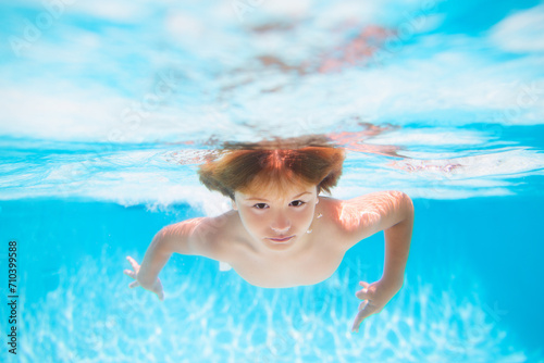 Kid boy swimming underwater on the beach on sea in summer. Blue ocean water. Child boy swimming in sea. © Volodymyr