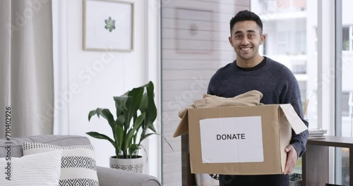 Man, face and donation in home, charity box and kindness with happy giving to ngo organisation. Volunteer, pride or smile portrait by clothing, cardboard or service to community with generosity photo