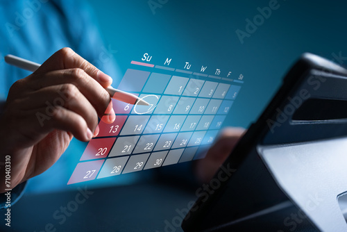 Secretary use tablet and touch virtual calendar screen. Make appointment or reminder for meeting agenda on the calendar. Time management concept. Businessman manages schedule for time-effective work.