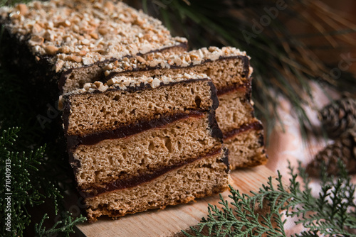 Piernik staropolski traditional christmas layered gingerbread cake with plum jam on wooden board, selective focus