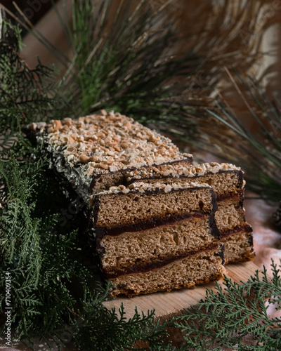 Piernik staropolski traditional christmas layered gingerbread cake with plum jam on wooden board, selective focus