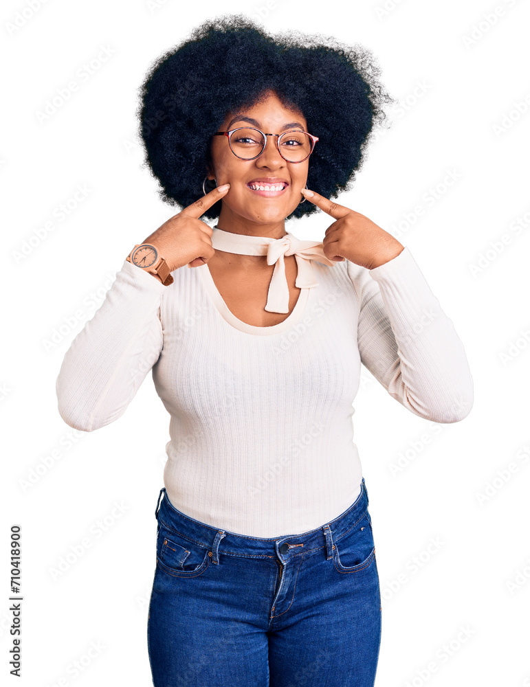 Young african american girl wearing casual clothes and glasses smiling with open mouth, fingers pointing and forcing cheerful smile Young african american girl wearing casual clothes and glasses smiling with open mouth, fingers pointing and forcing cheerful smile