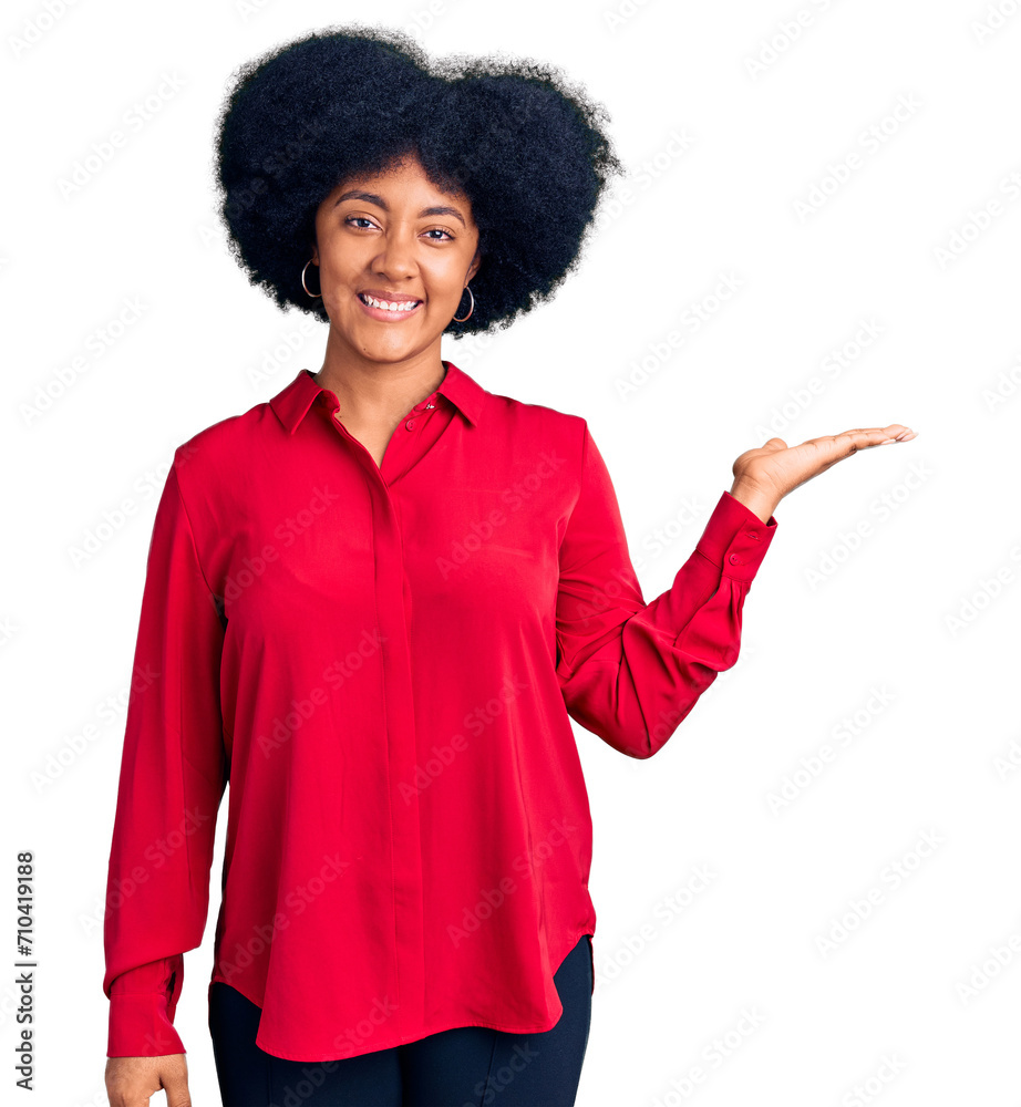 Young african american girl wearing casual clothes smiling cheerful presenting and pointing with palm of hand looking at the camera. Young african american girl wearing casual clothes smiling cheerful presenting and pointing with palm of hand looking at the camera.