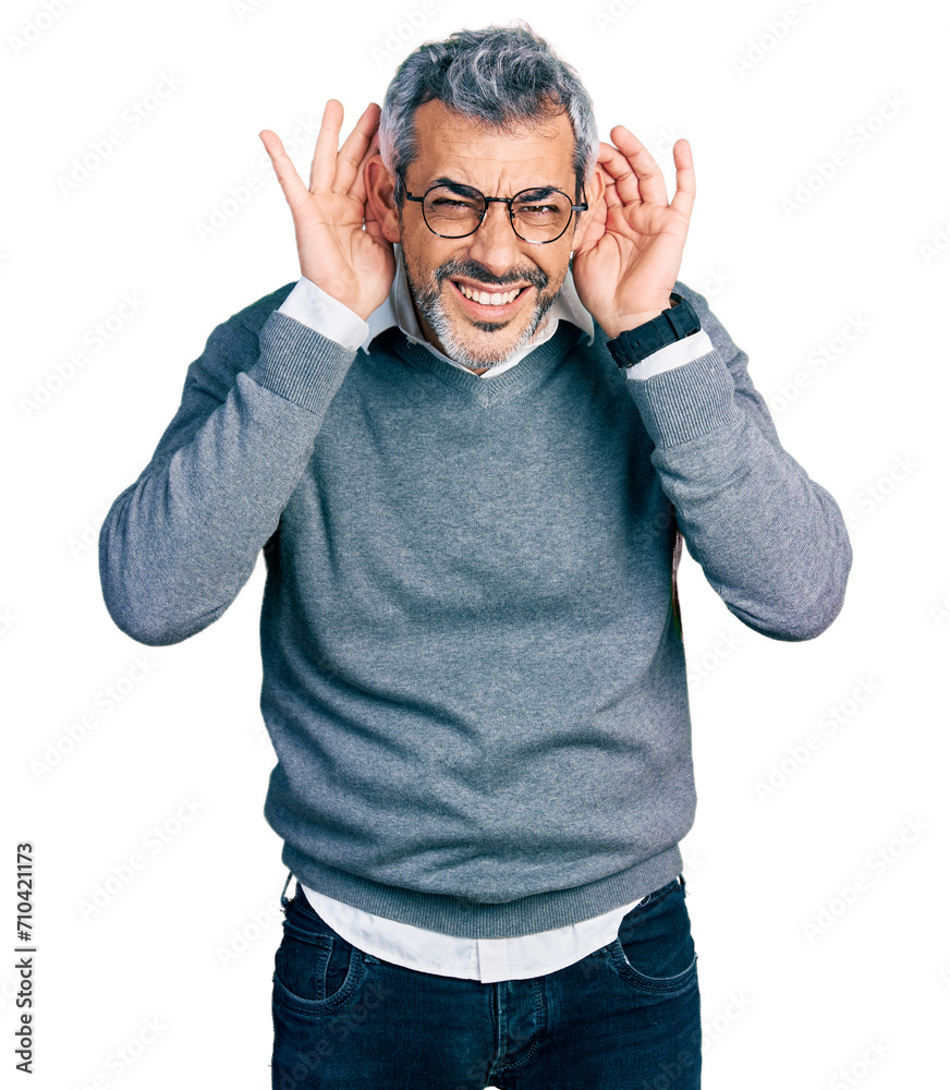 Middle age hispanic with grey hair wearing glasses trying to hear both hands on ear gesture, curious for gossip. hearing problem, deaf Middle age hispanic with grey hair wearing glasses trying to hear both hands on ear gesture, curious for gossip. hearing problem, deaf