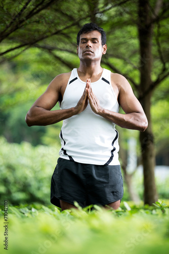 Indian man doing yoga exercise in park