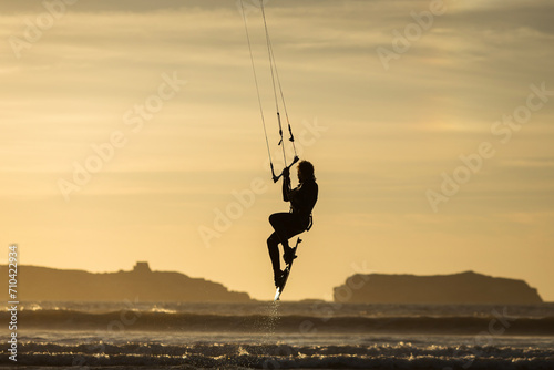 Silhouette of kitesurfer on the beach with reflection at sunset in background. Essaouira, Morocco photo