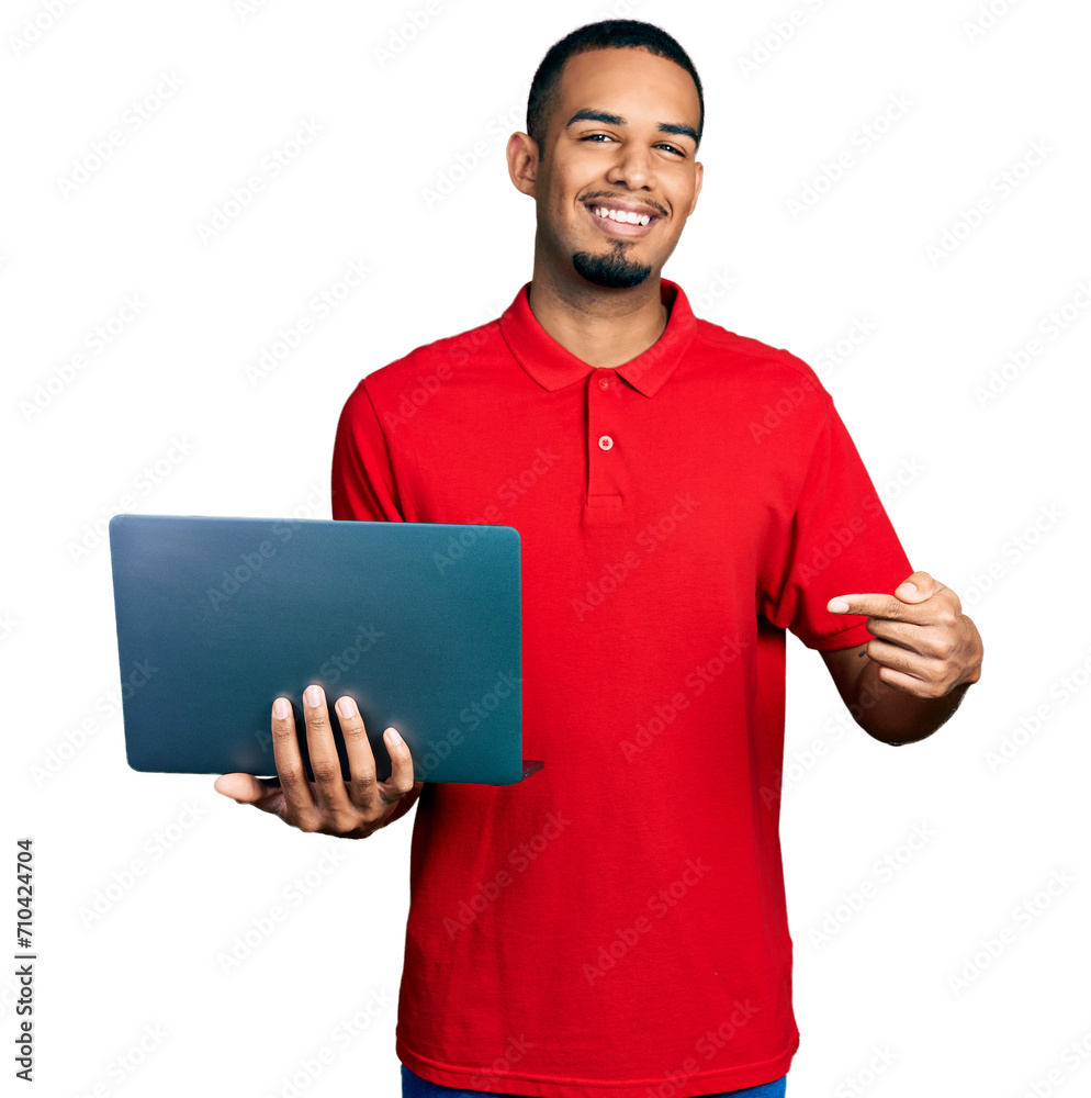 Young african american man working using computer laptop smiling happy pointing with hand and finger Young african american man working using computer laptop smiling happy pointing with hand and finger