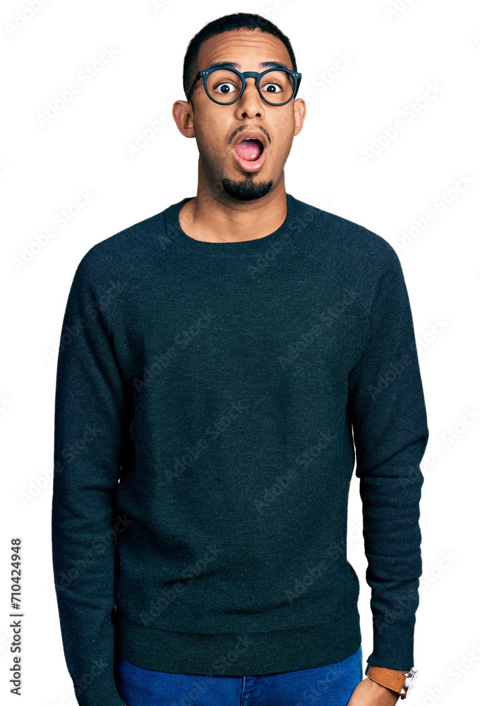 Fototapeta premium Young african american man wearing casual clothes and glasses afraid and shocked with surprise expression, fear and excited face.