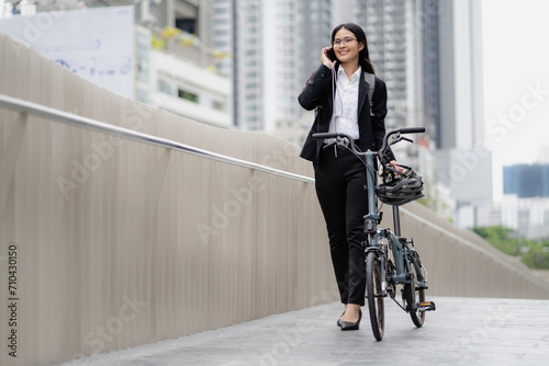 Eco friendly vehicle. 20s businesswoman ride bicycle in downtown . Cycling has no pollution, alternative energy to global warming carbon footprint. Environmentalist riding bicycling. Commuting by bike