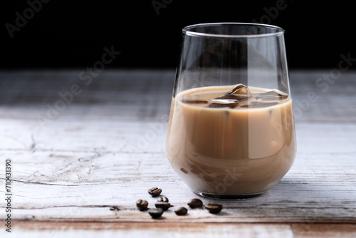 Traditional Irish cream coffee liqueur with ice on wooden table. Copy space photo