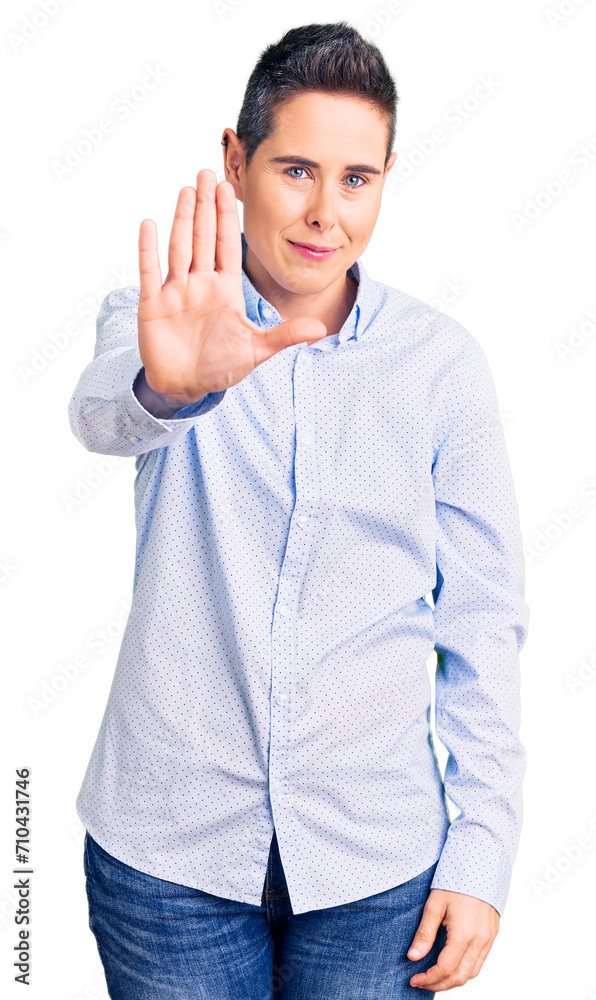 Young woman with short hair wearing business clothes doing stop sing with palm of the hand. warning expression with negative and serious gesture on the face. Young woman with short hair wearing business clothes doing stop sing with palm of the hand. warning expression with negative and serious gesture on the face.
