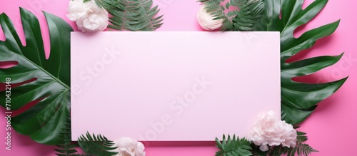 Top view of arranged tropical green plants and white frame copy space on pink background.Generate AI