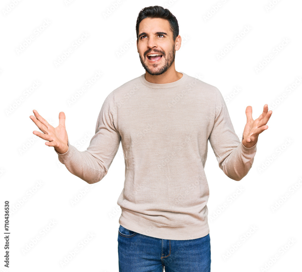 Young hispanic man wearing casual clothes crazy and mad shouting and yelling with aggressive expression and arms raised. frustration concept. Young hispanic man wearing casual clothes crazy and mad shouting and yelling with aggressive expression and arms raised. frustration concept.