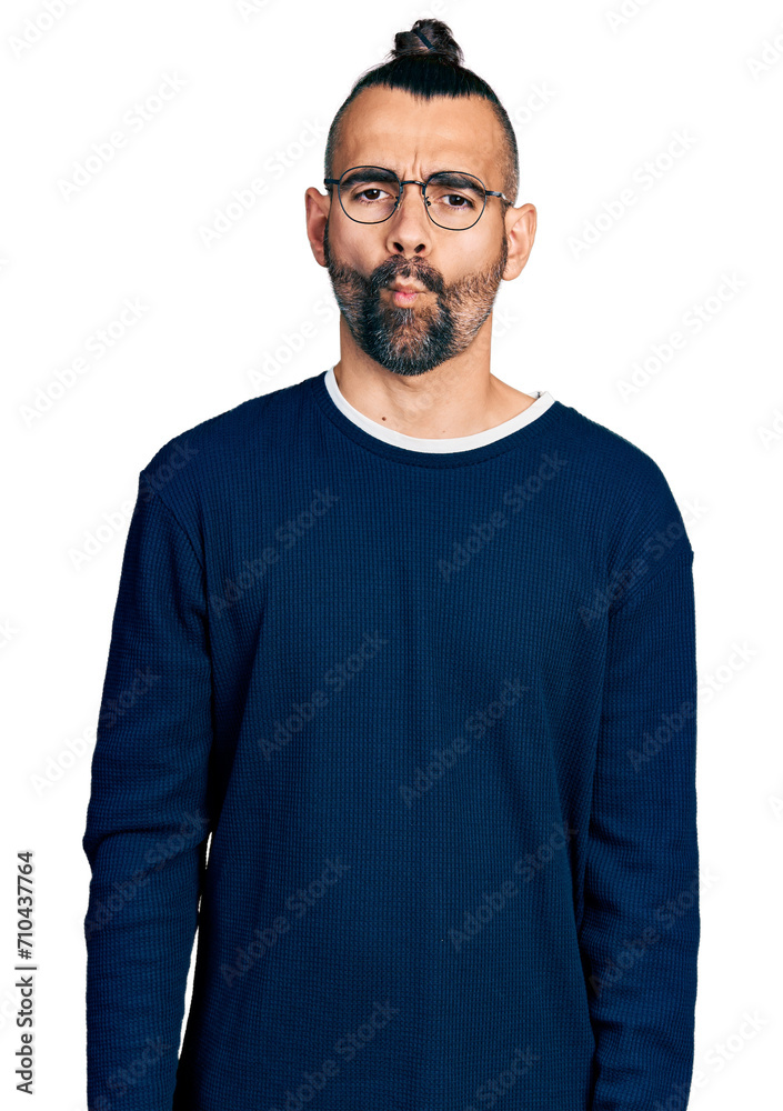 Hispanic man with ponytail wearing casual sweater and glasses making fish face with lips, crazy and comical gesture. funny expression.