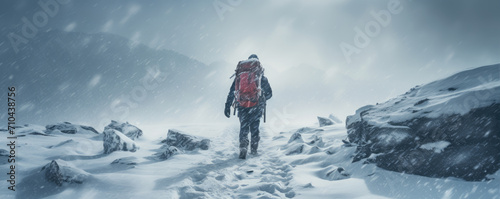 Man hiking in heavy snow storm in winter moutains. face covered with snow, copy space for text.