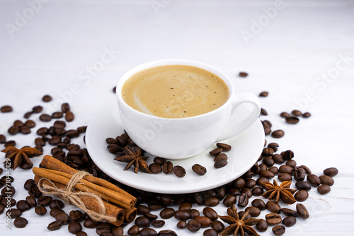 A cup of aromatic cappuccino and coffee beans on the white wooden table. Close-up. Selective focus. © Markoff