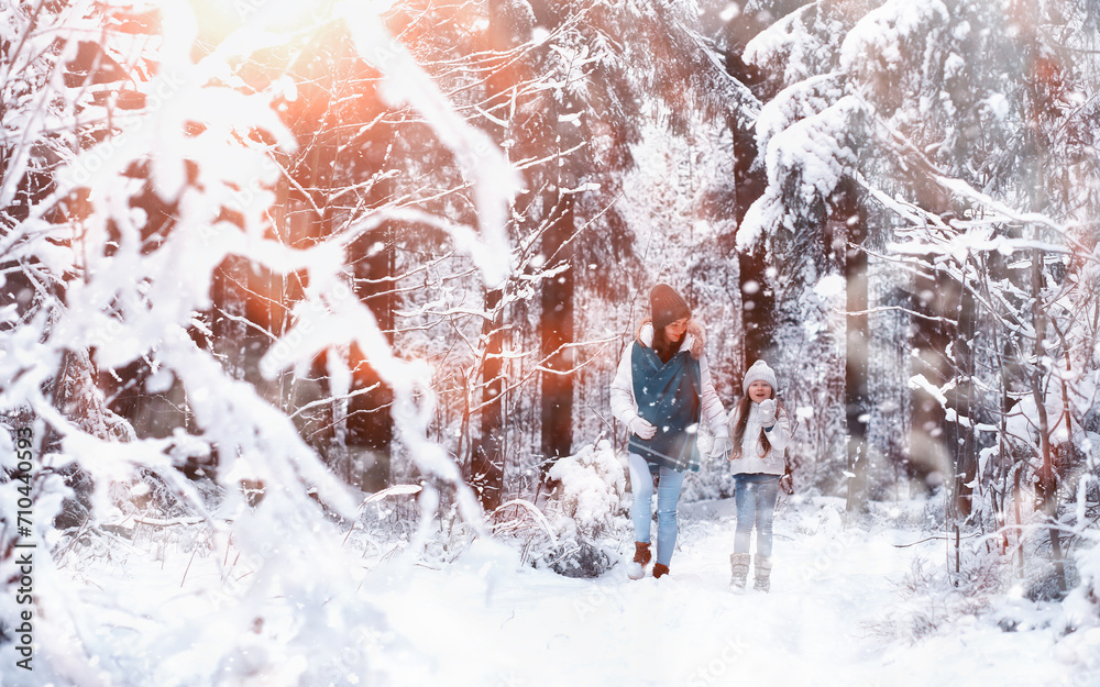 © alexkich - Young family for a walk. Mom and daughter are walking in a winter park. © alexkich - Young family for a walk. Mom and daughter are walking in a winter park.