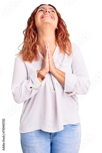 Young latin woman wearing casual clothes begging and praying with hands together with hope expression on face very emotional and worried. begging.