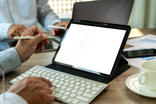 A businessman holds a mockup. iPad digital tablet with blank screen Mockup replaces your design mockup in the office.