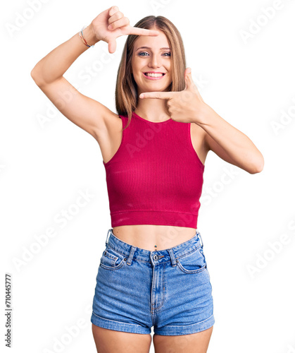 Young beautiful blonde woman wearing elegant summer shirt smiling making frame with hands and fingers with happy face. creativity and photography concept.