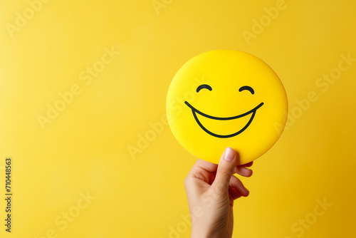hand holding a wooden seeded circle on a yellow background