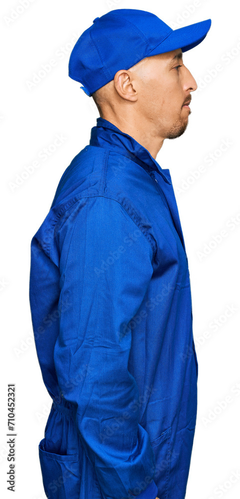 Bald man with beard wearing builder jumpsuit uniform looking to side, relax profile pose with natural face and confident smile. Bald man with beard wearing builder jumpsuit uniform looking to side, relax profile pose with natural face and confident smile.