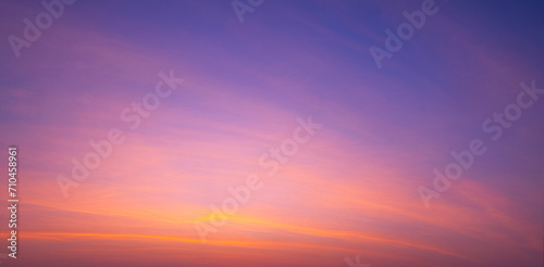 Sunset sky background with beautiful pink sunrise clouds on colorful dramatic twilight sky in panoramic view 